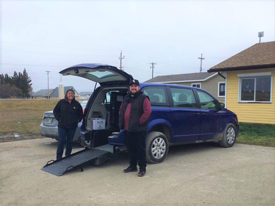 Staff from sagkeeng first nation standing beside rear entry dodge grand caravan during delivery