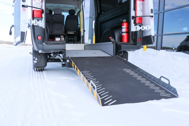 Rear entry wheelchair van with manual ram and grab handles.