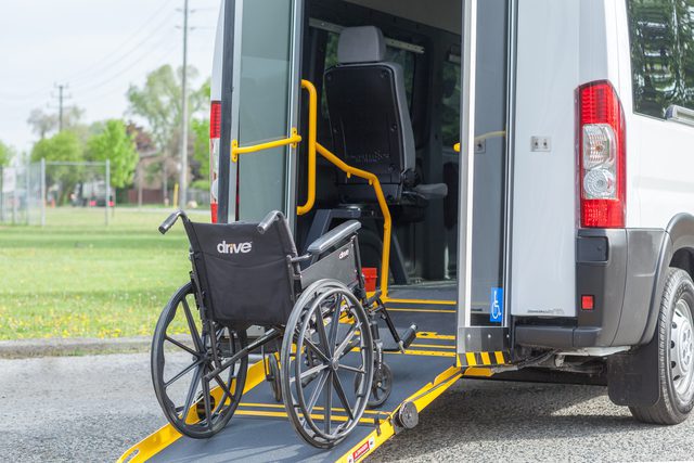Rear view of rear entry P4 wheelchair van with ramp and wheelchair going up the ramp.