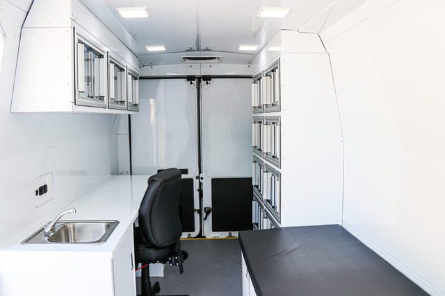 Inside Mobile Medical Clinic Van with exam bed and doctors office space